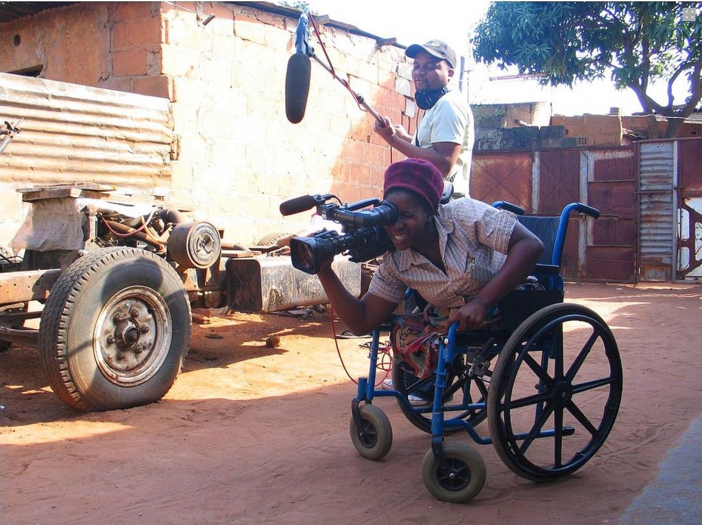 Ein Mann im Rollstuhl filmt mit einer Kamera, über ihm hängt ein Mikrophon